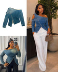 Washed-blue long-sleeve denim top with asymmetric neckline, shoulder cut-out and diagonal buttons